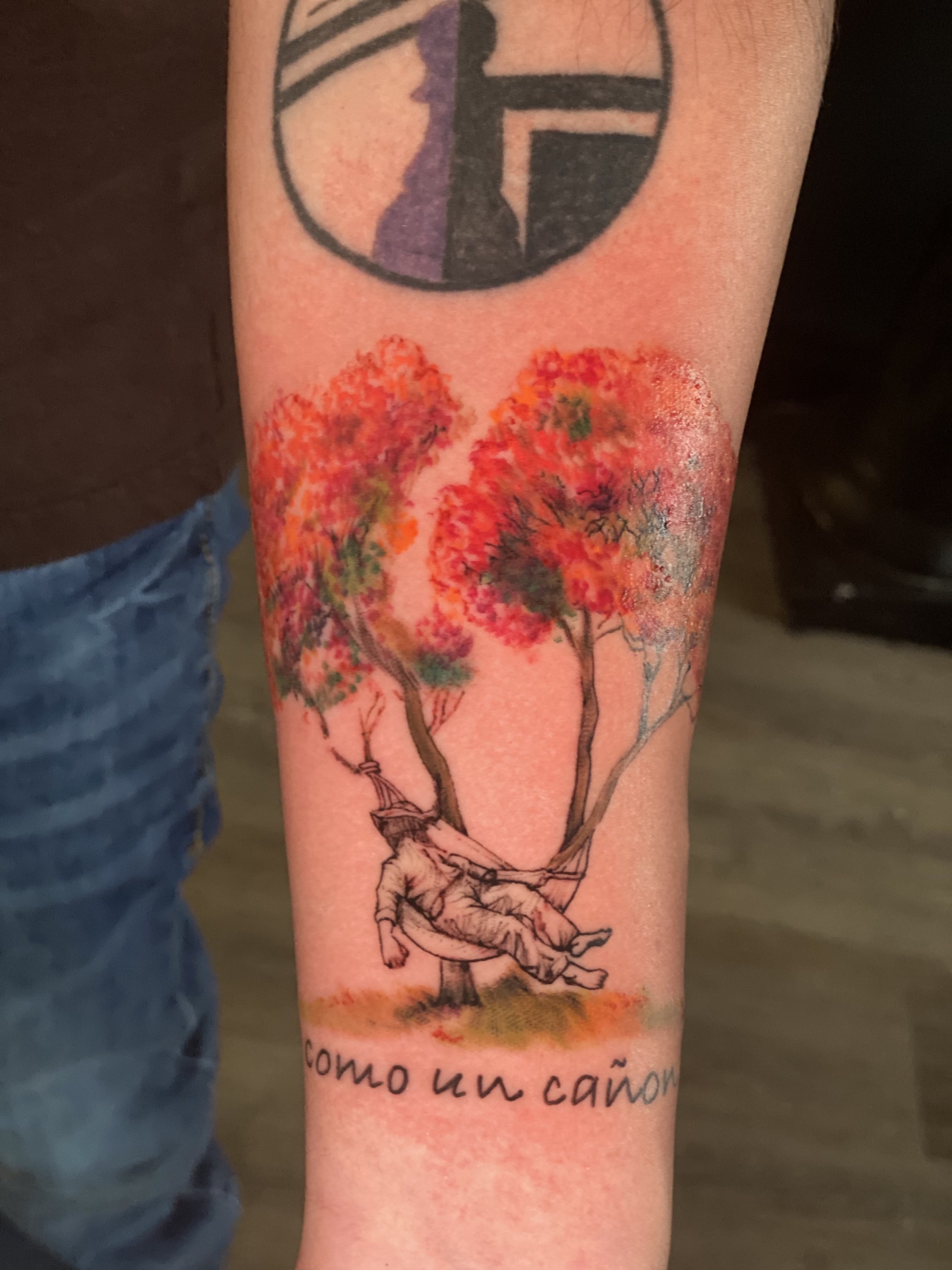 Watercolor-style trees and figure tattoo